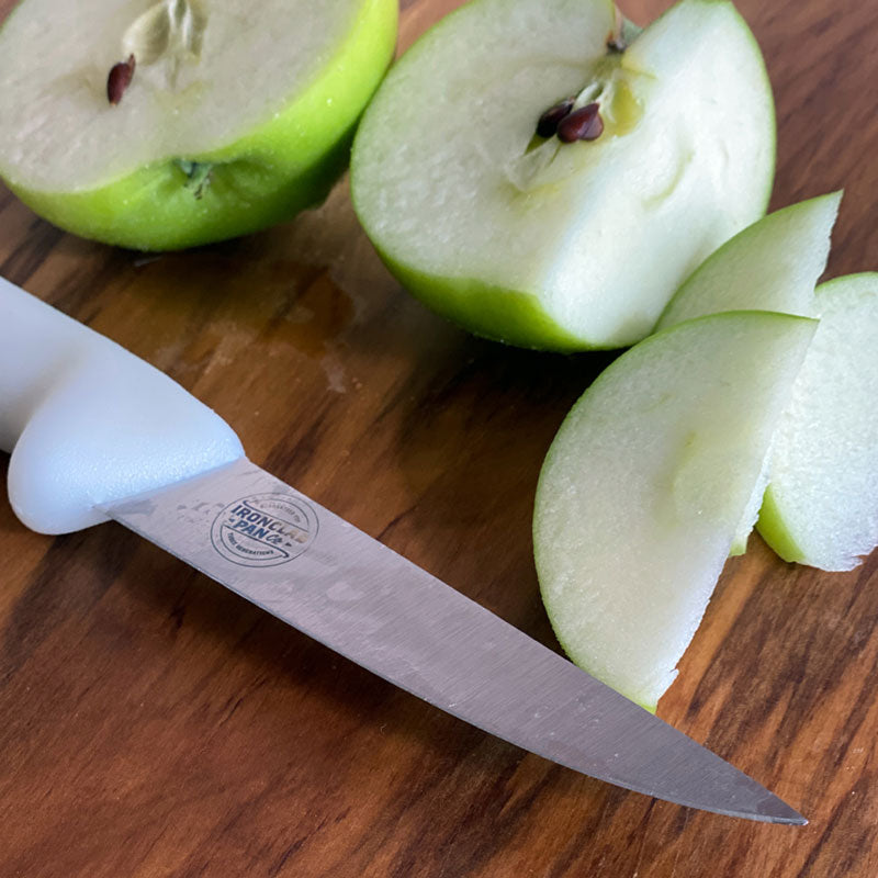 Paring knife blade up close with apples